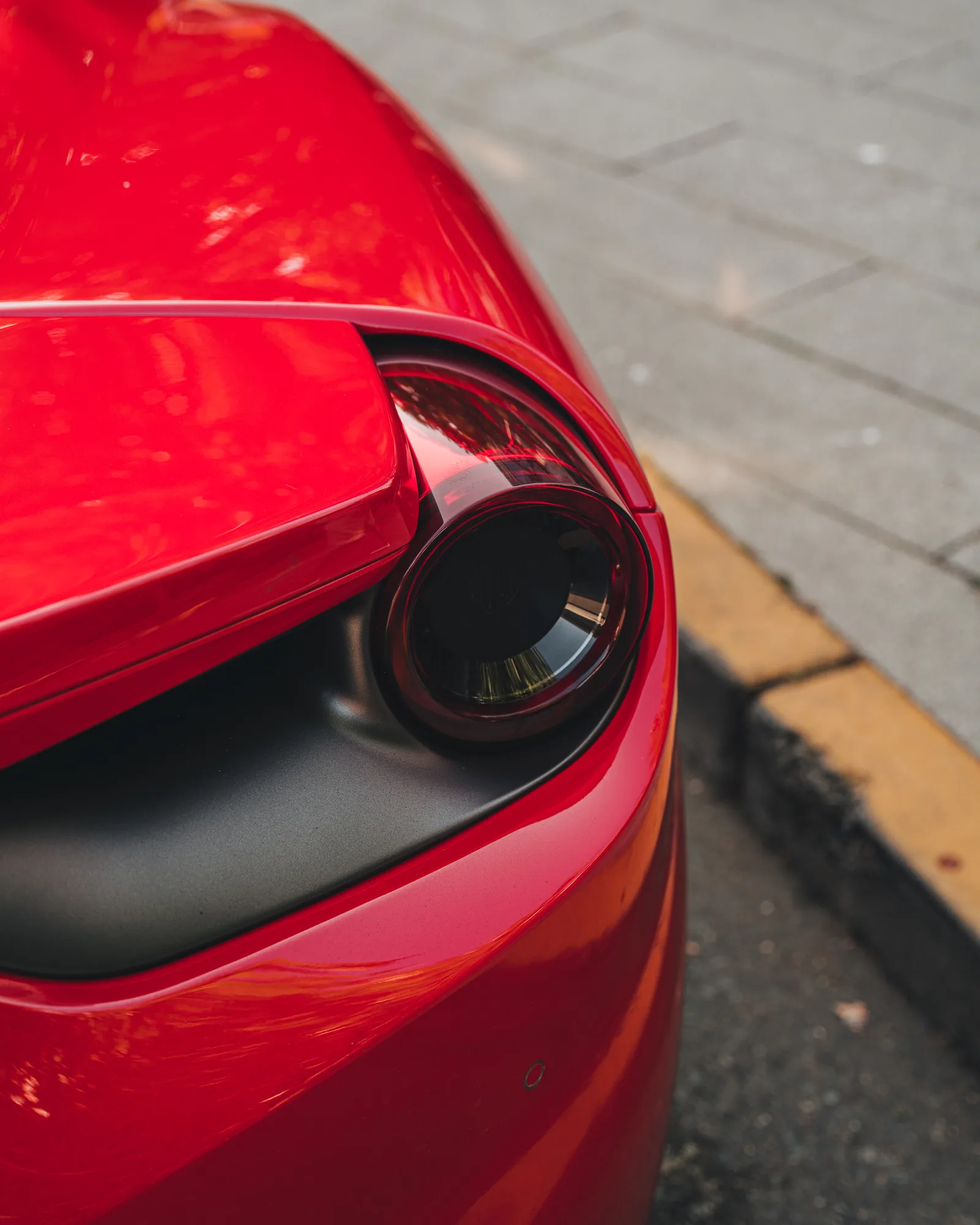 Close-up of the round tail light on a red Ferrari