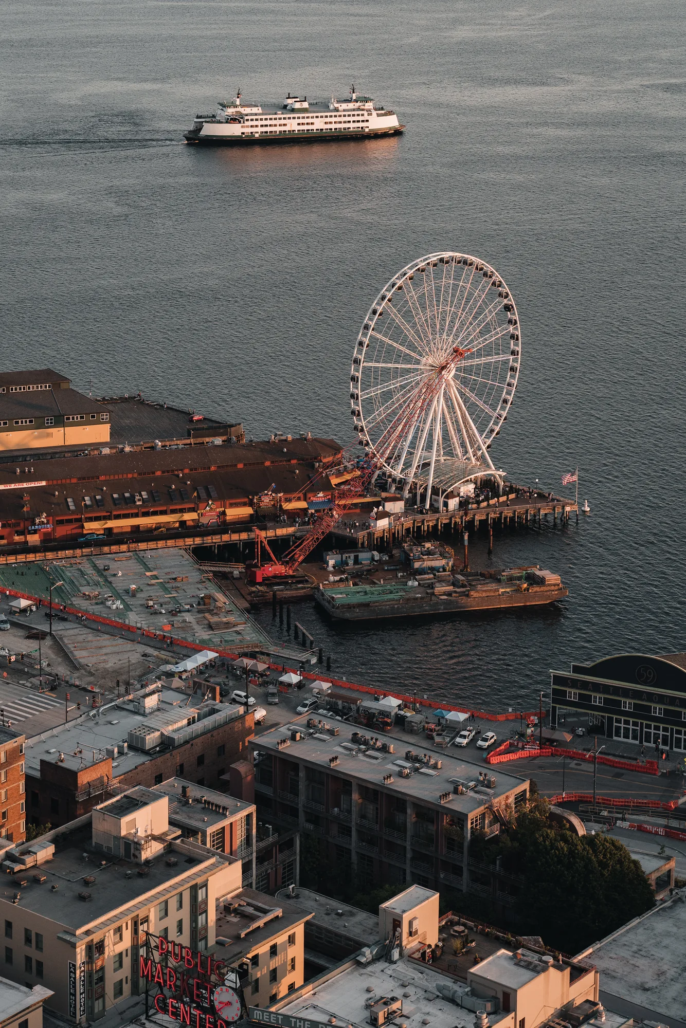Aerial view of the Seattle waterfront with the Ferris wheel and a ferry at sunset